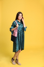Photo of Full length portrait of young woman with textile bag on yellow background