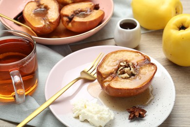 Photo of Delicious quince baked with honey and walnuts on wooden table