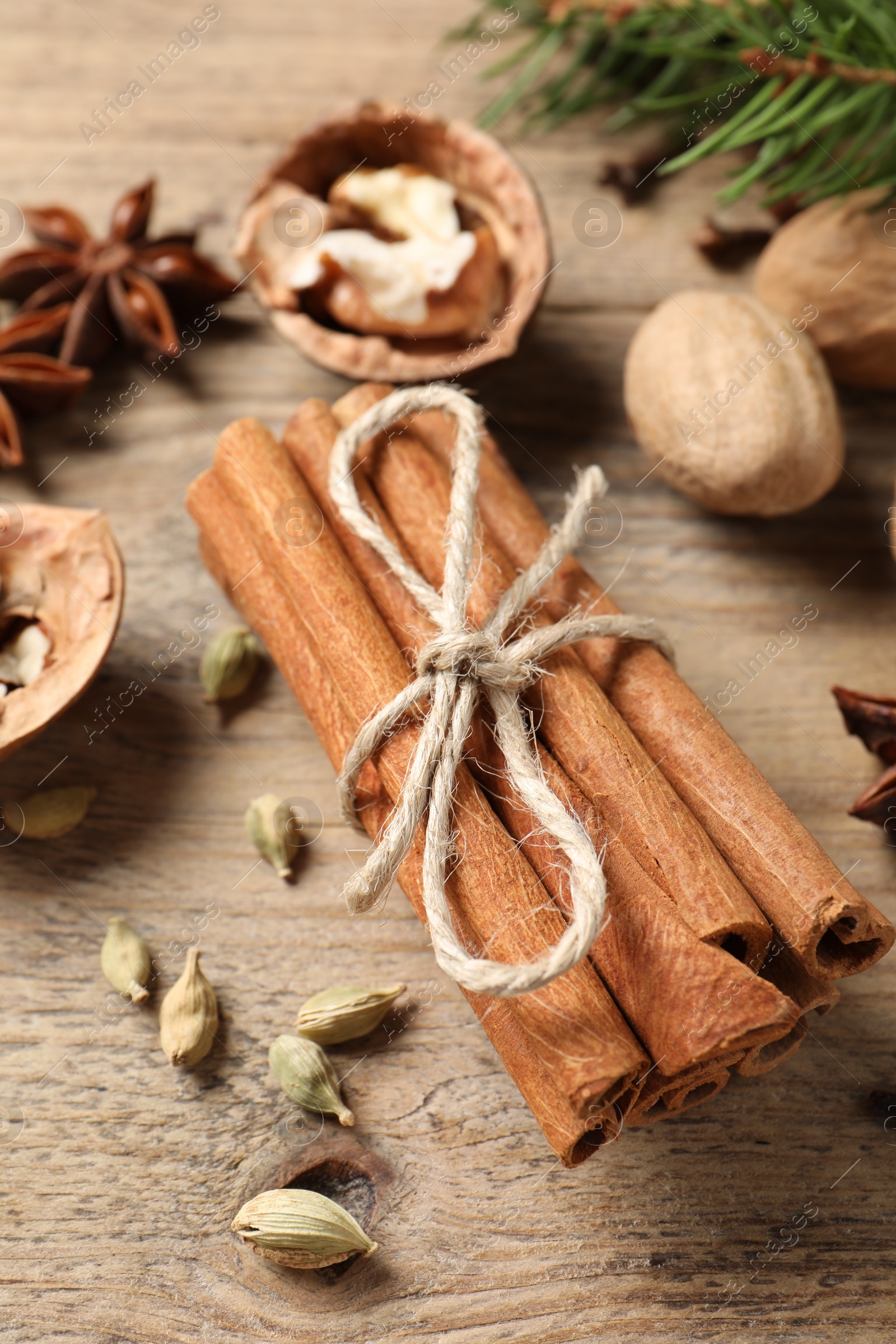 Photo of Different spices and nuts on wooden table, above view