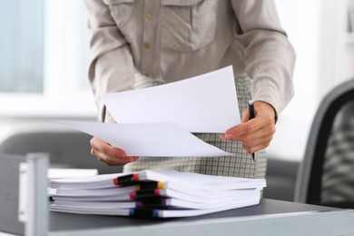 Photo of Businesswoman with documents near table in office, closeup