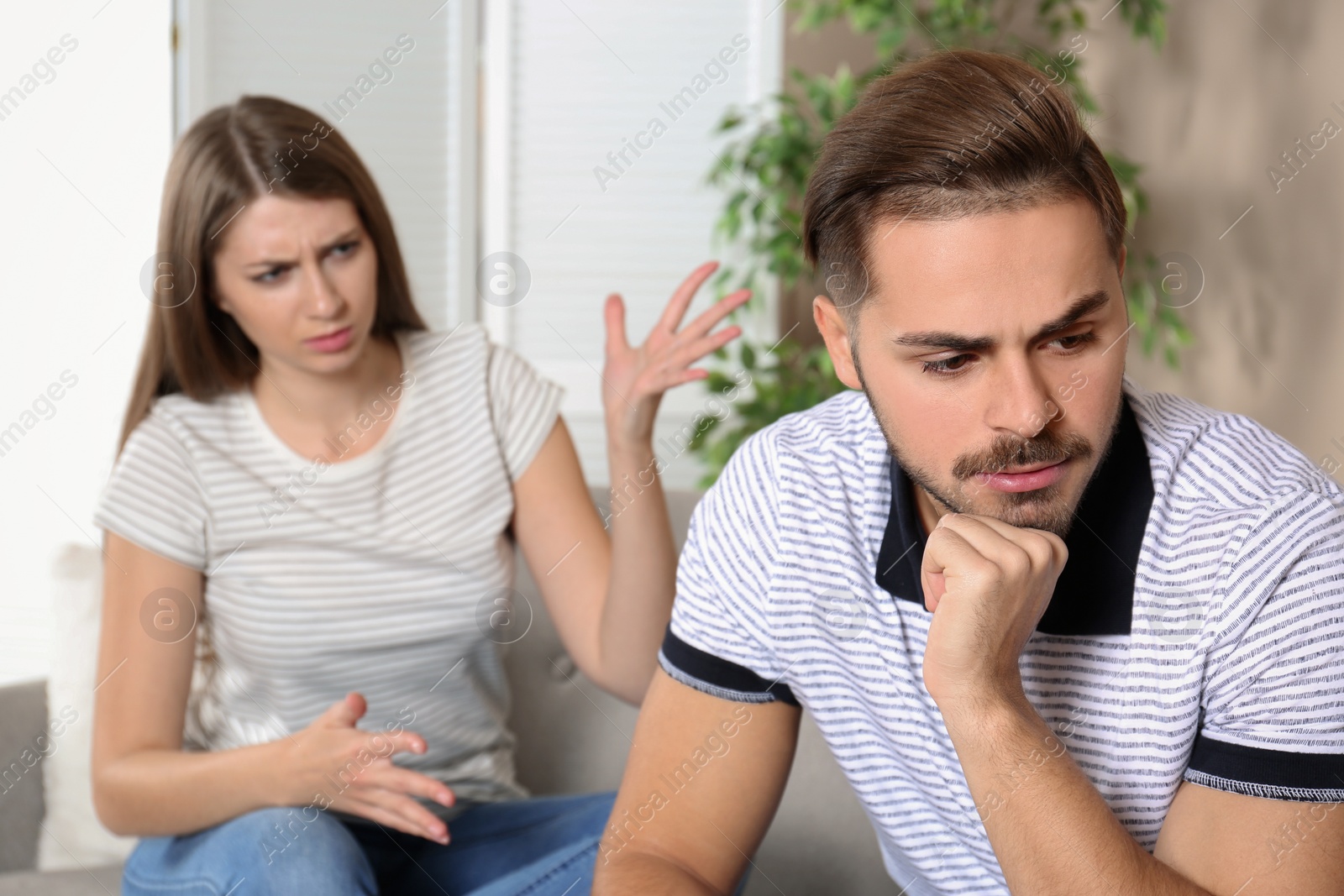 Photo of Young couple arguing in living room. Relationship problems