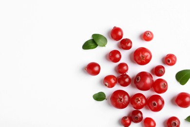 Fresh ripe cranberries and green leaves on white background, flat lay. Space for text