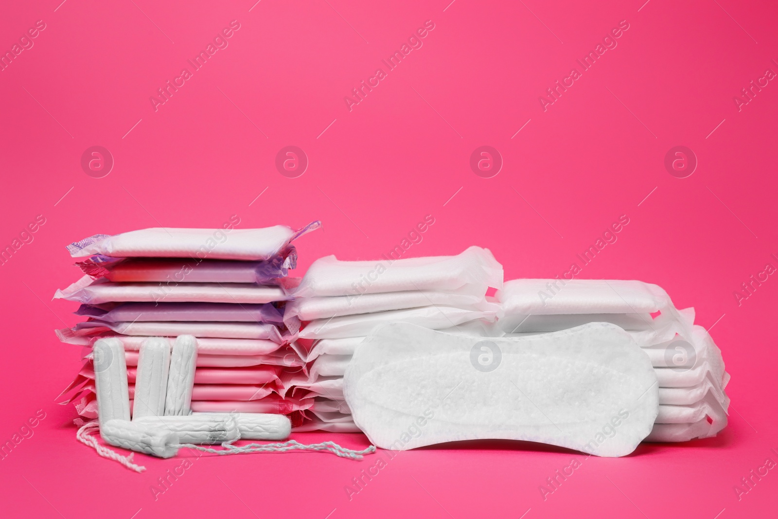 Photo of Many menstrual pads and tampons on pink background