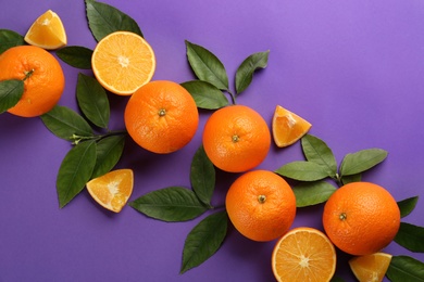 Delicious oranges on purple background, flat lay