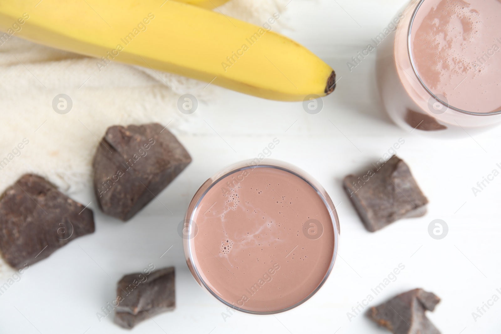 Photo of Yummy chocolate milk and fresh ingredients on white wooden table, flat lay