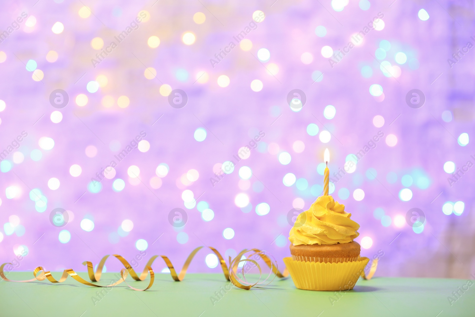 Photo of Birthday cupcake with candle against blurred lights