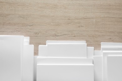 Photo of Stacks of white paper sheets on wooden table, flat lay. Space for text