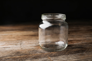 Photo of Open empty glass jar on wooden table