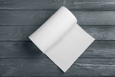 Roll of paper towels on grey wooden table, top view