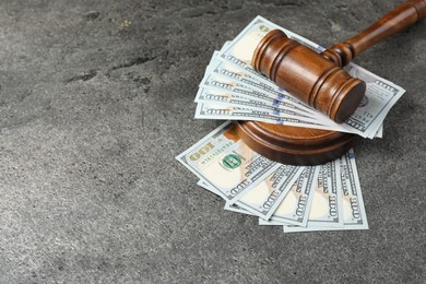 Photo of Judge's gavel and money on grey table. Space for text