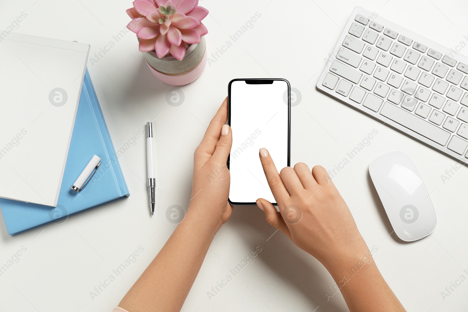 Photo of Woman using smartphone at white table, top view