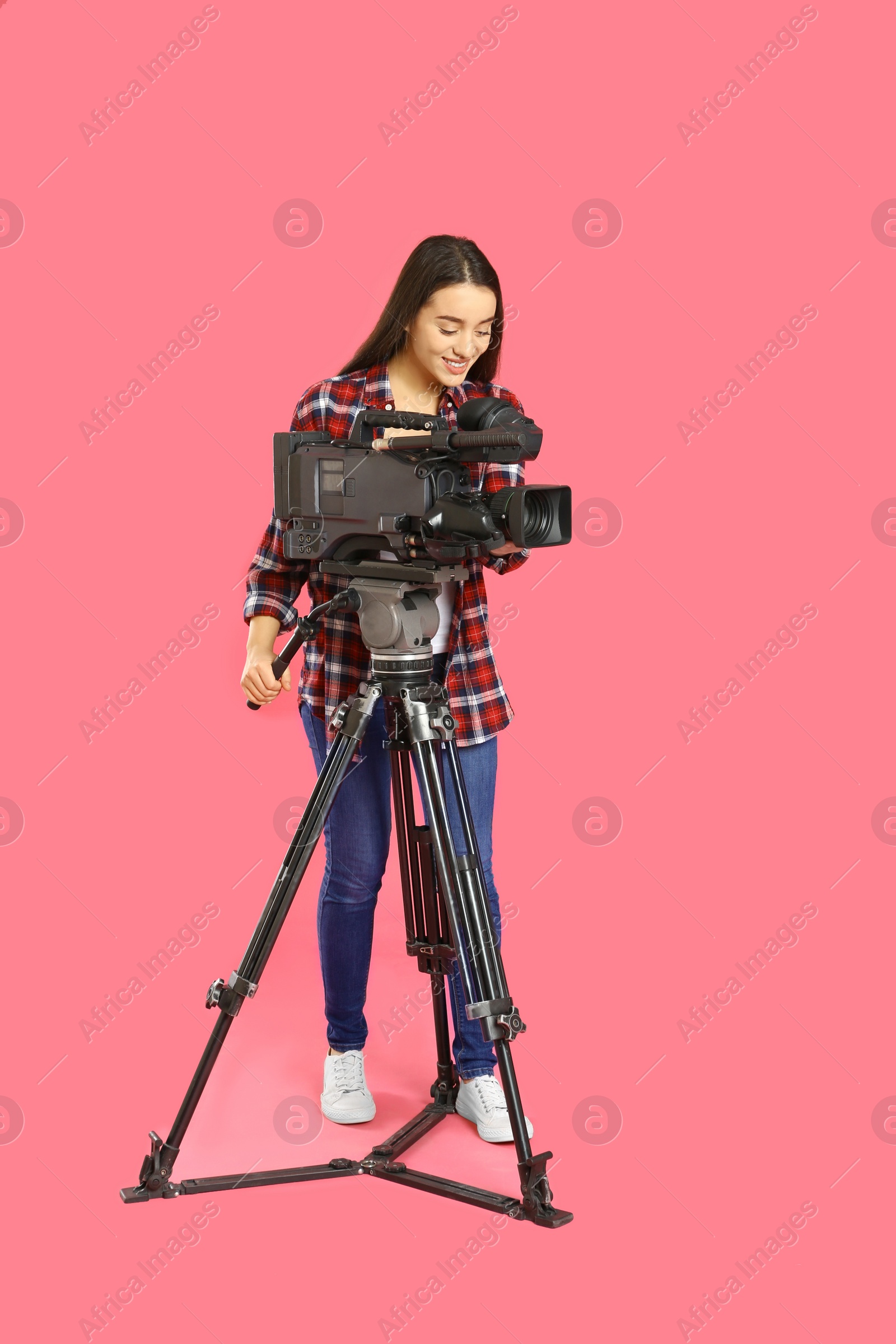 Photo of Operator with professional video camera on pink background