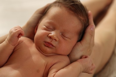Photo of Woman holding her sleeping newborn baby, closeup