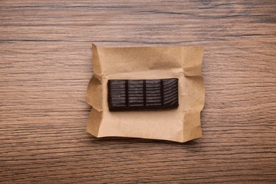 Photo of Hematogen bar with parchment wrapper on wooden table, top view