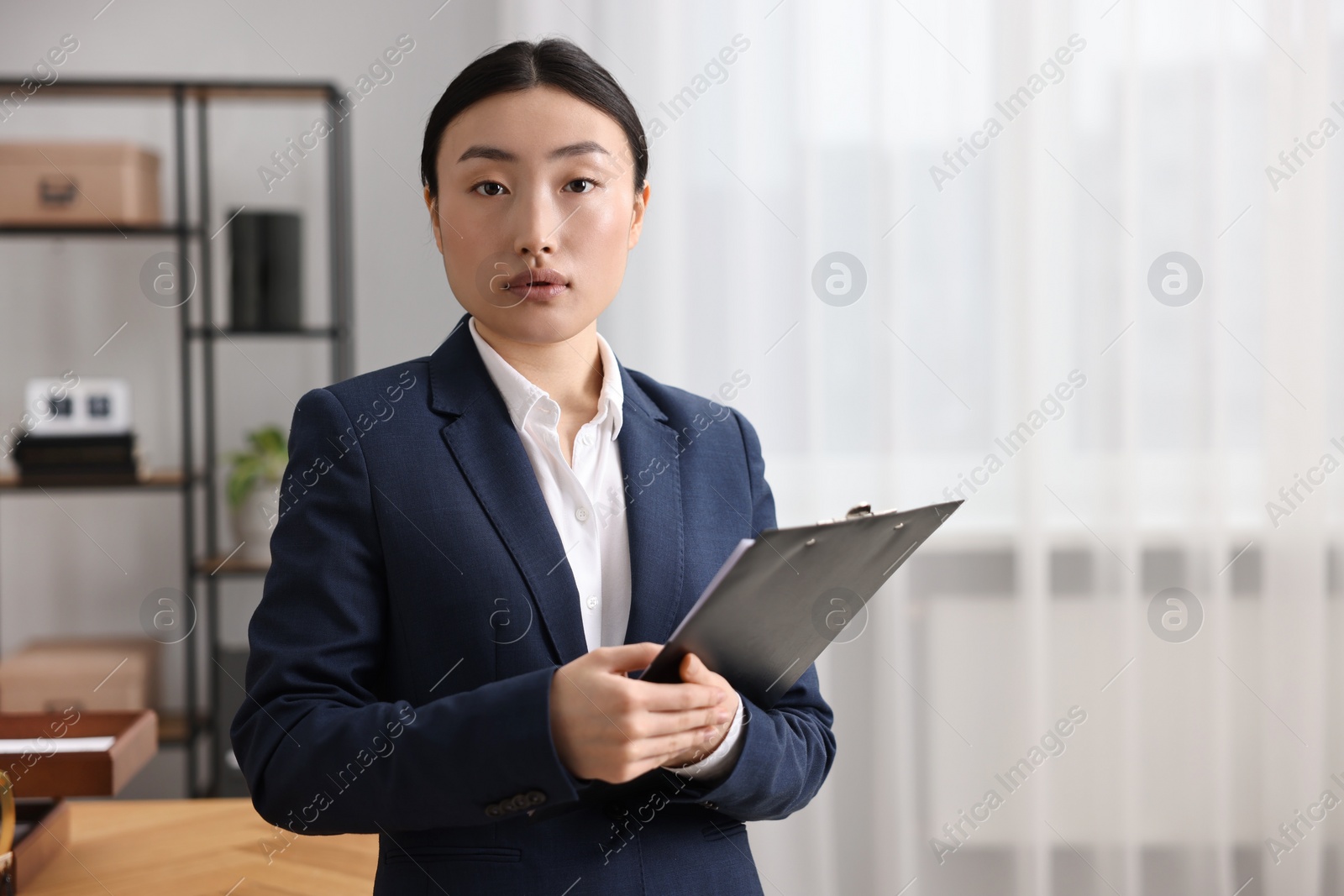 Photo of Portrait of notary with clipboard in office. Space for text