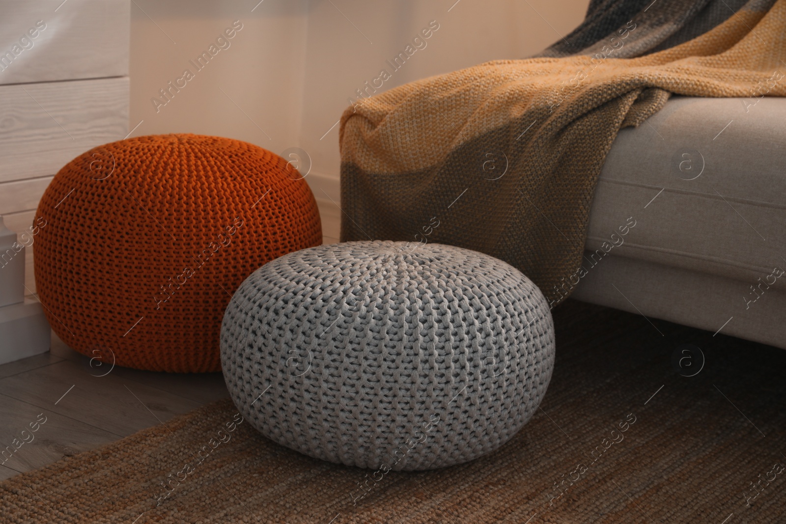 Photo of Stylish comfortable poufs near sofa in room. Home design