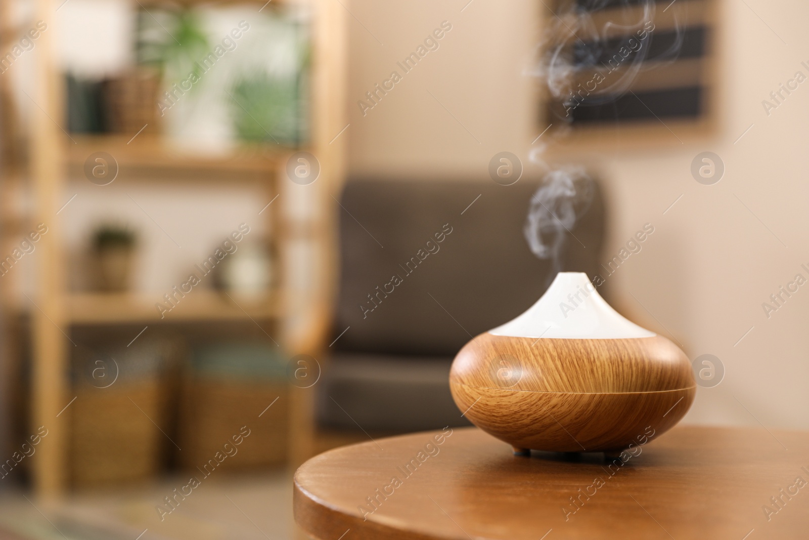 Photo of Aroma oil diffuser on wooden table at home, space for text. Air freshener