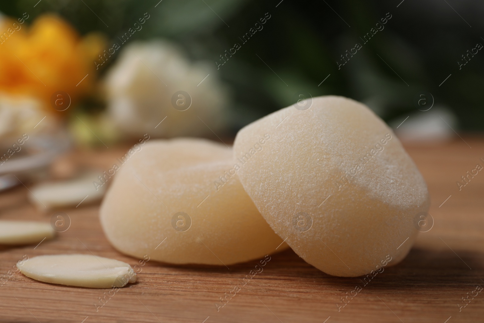 Photo of Delicious mochi and almond flakes on wooden table, closeup. Traditional Japanese dessert