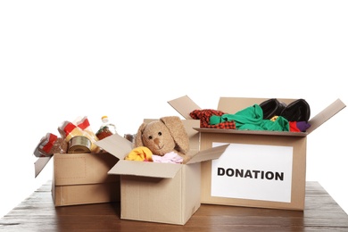 Carton boxes with donations on table against white background