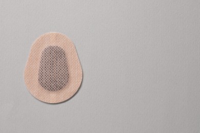 Photo of Contraceptive patch on light grey background, top view. Space for text