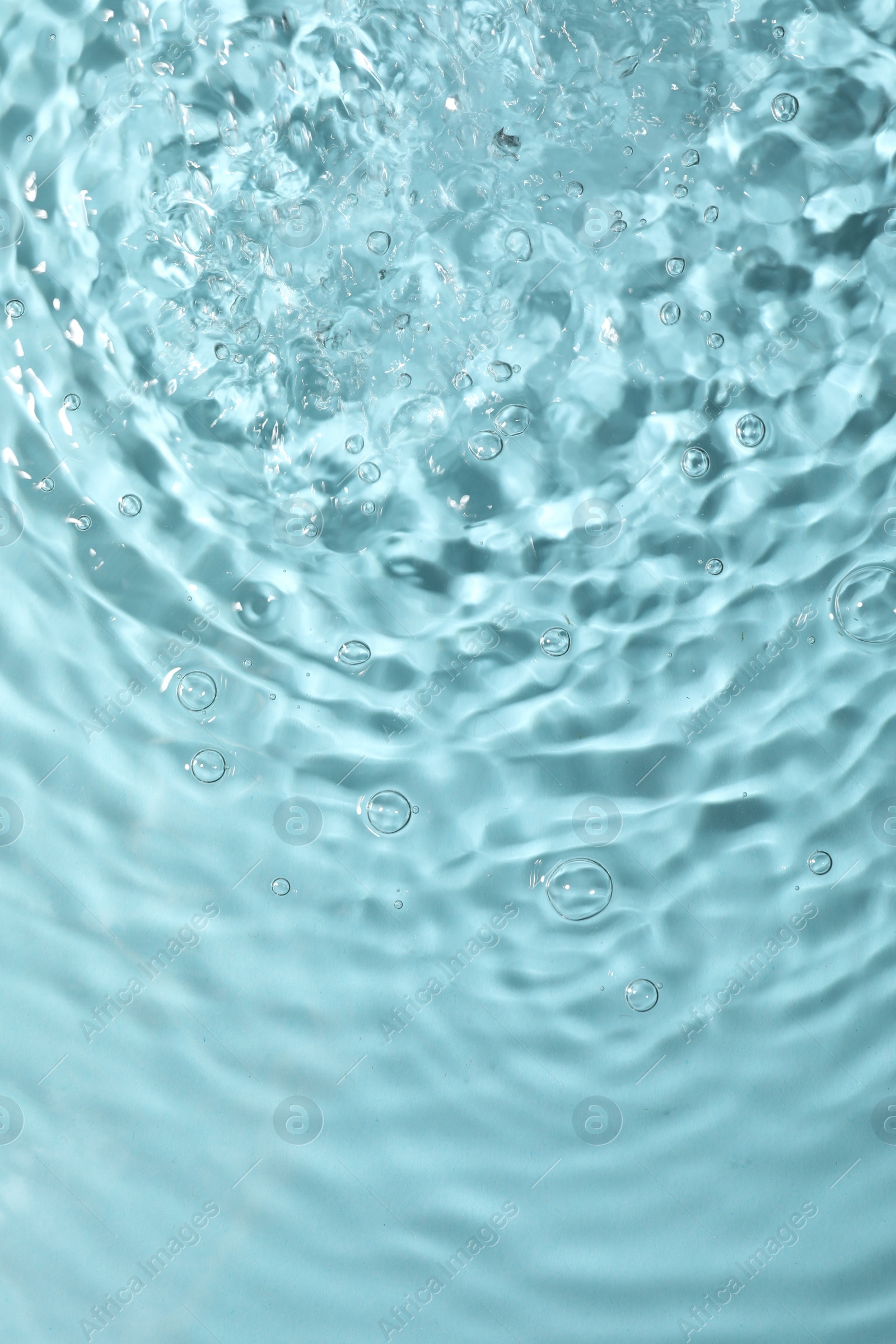 Photo of Closeup view of water with rippled surface on light blue background