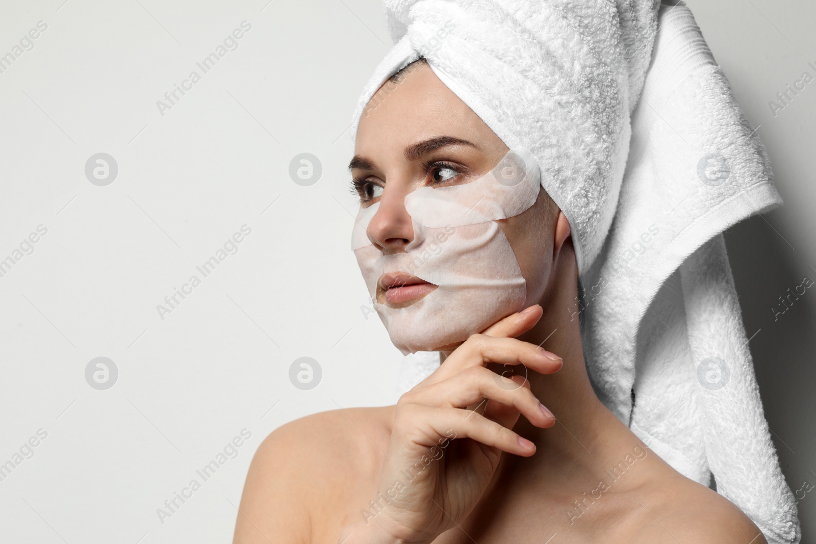 Photo of Beautiful woman with cotton face and eye masks against light background. Space for text