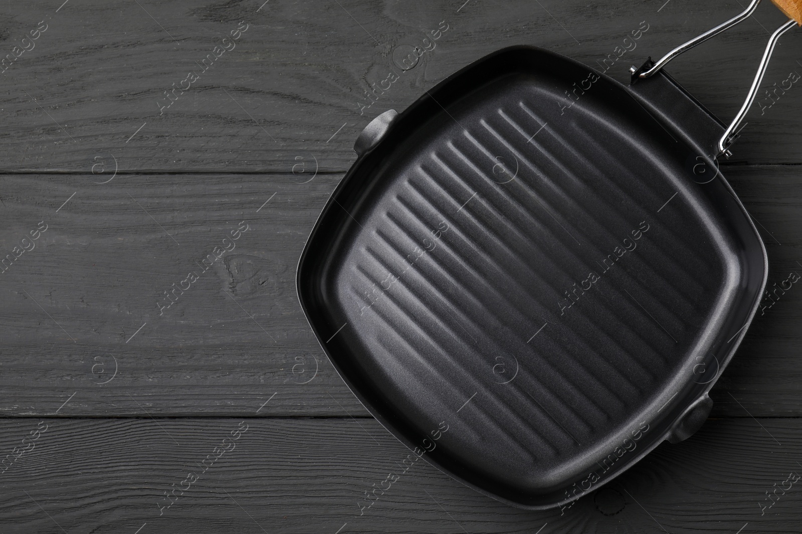 Photo of One frying pan on grey wooden table, top view. Space for text