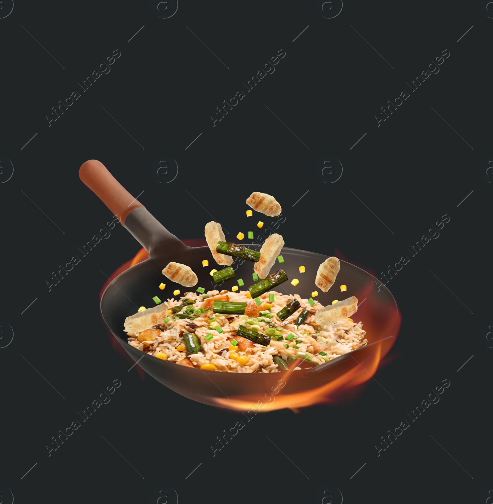 Image of Wok with tasty ingredients and fire on dark background