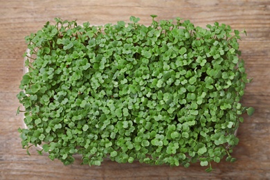 Fresh organic microgreen on wooden table, top view