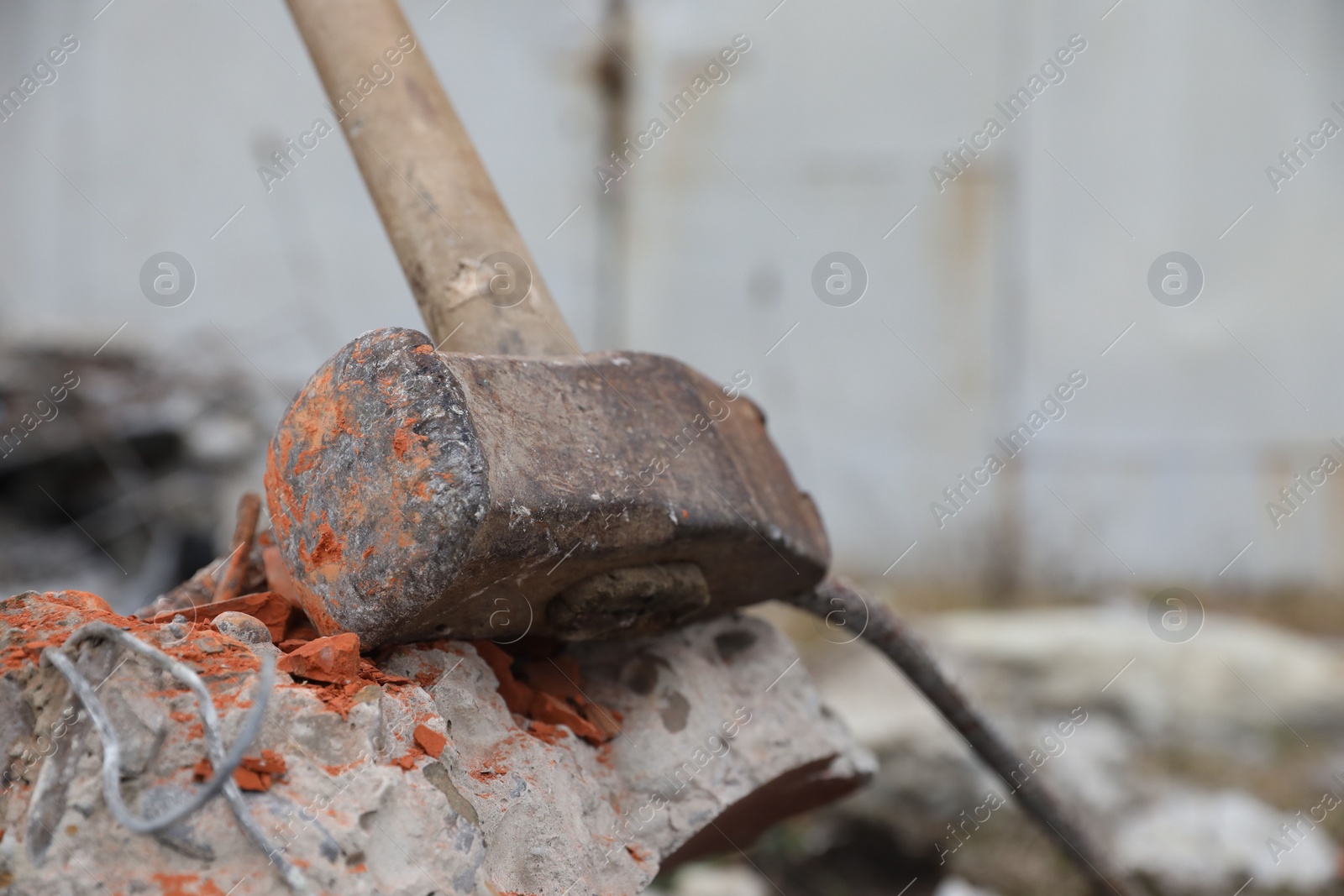 Photo of Sledgehammer on crushed brick outdoors, closeup. Space for text