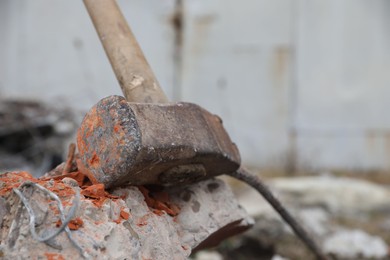 Sledgehammer on crushed brick outdoors, closeup. Space for text