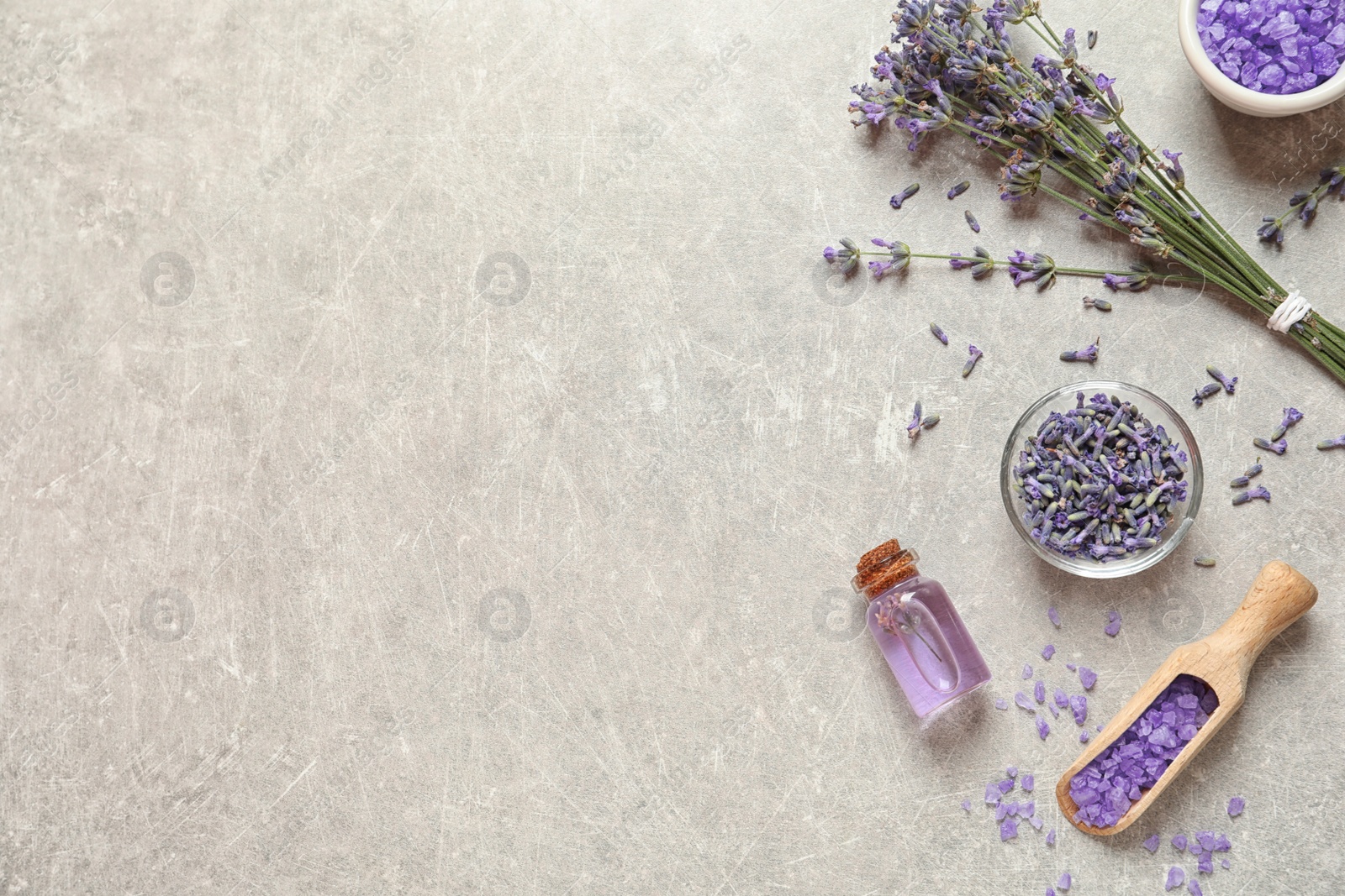 Photo of Flat lay composition with natural cosmetic products and lavender flowers on grey stone background. Space for text