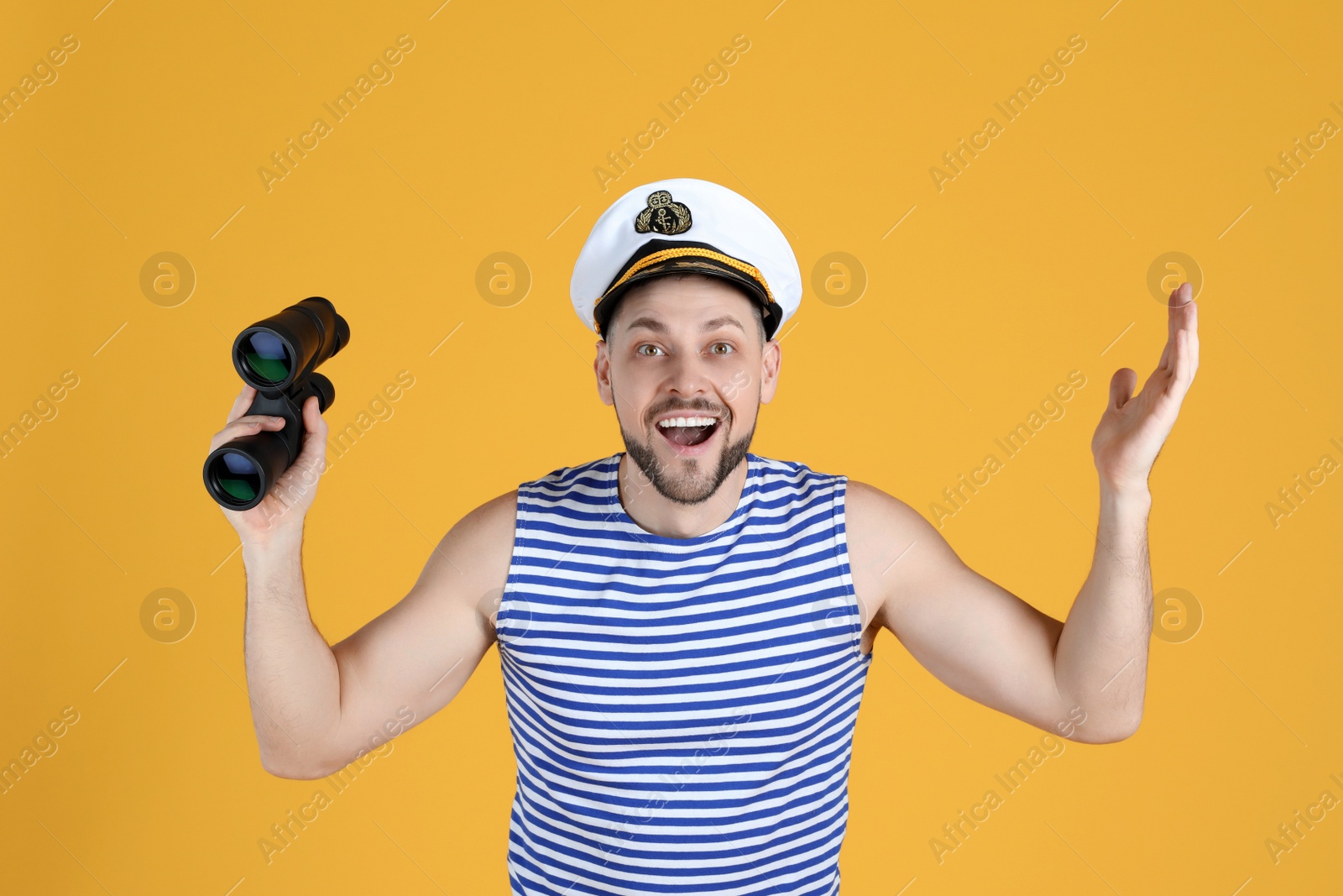 Photo of Happy sailor with binoculars on yellow background