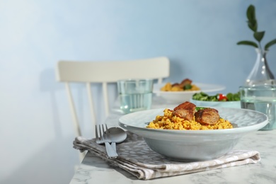 Plate with delicious rice pilaf served on table. Space for text