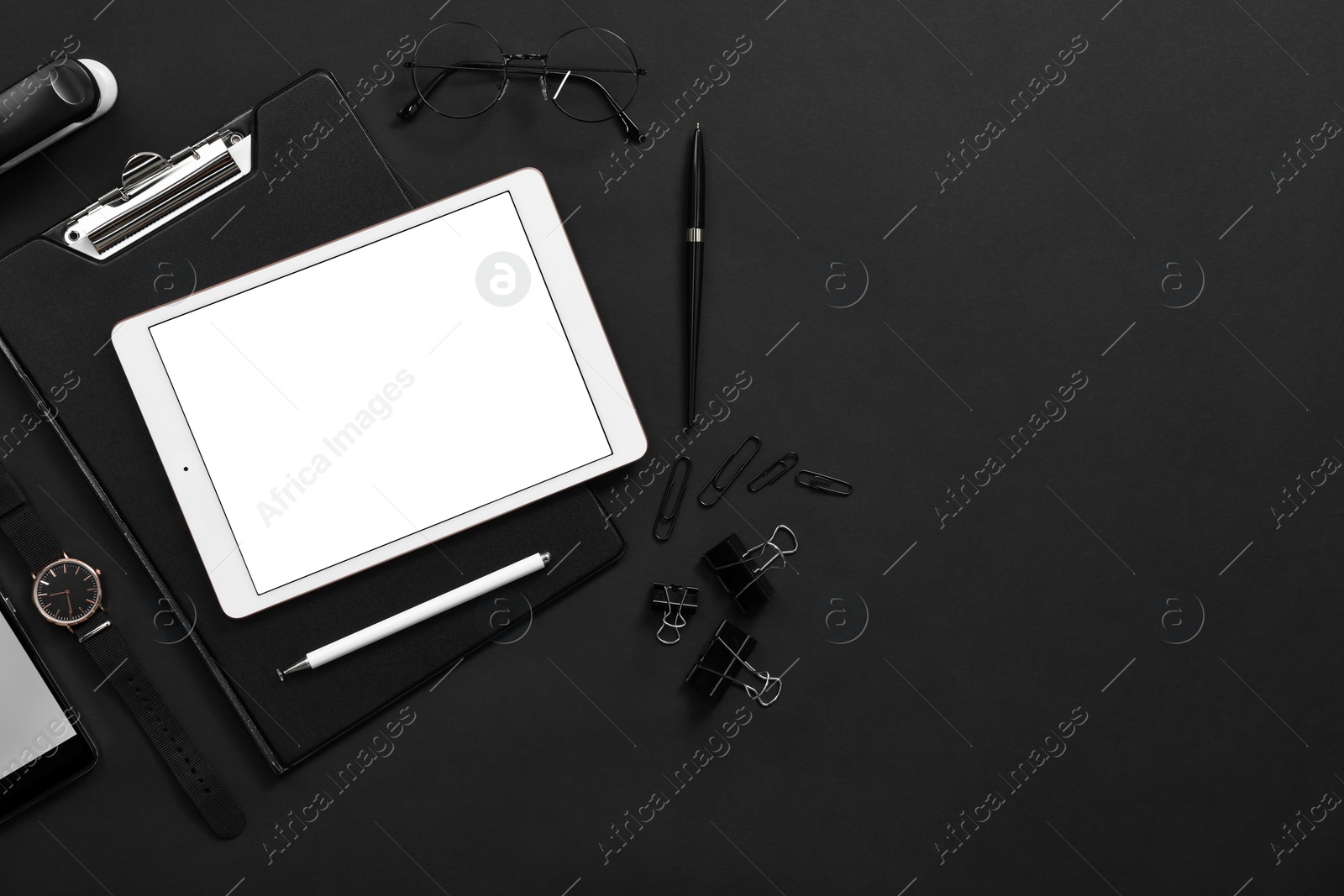 Photo of Modern tablet, stationery, wristwatch and glasses on black background, flat lay. Space for text