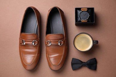 Photo of Male accessories on brown background, flat lay