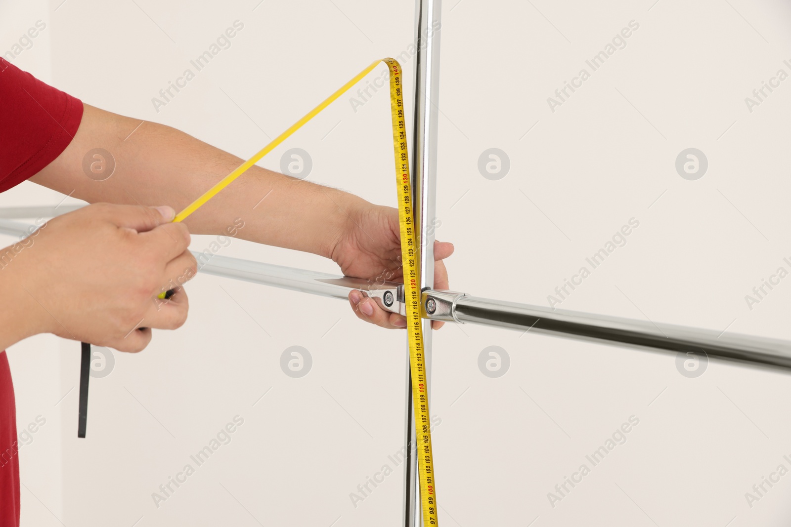 Photo of Worker measuring metal pipes for installation, closeup