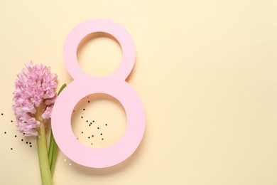 Photo of 8th of March greeting card design with paper number eight, beautiful flowers and space for text on beige background, flat lay. International Women's day