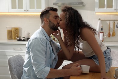 Photo of Lovely couple enjoying time together at table in kitchen