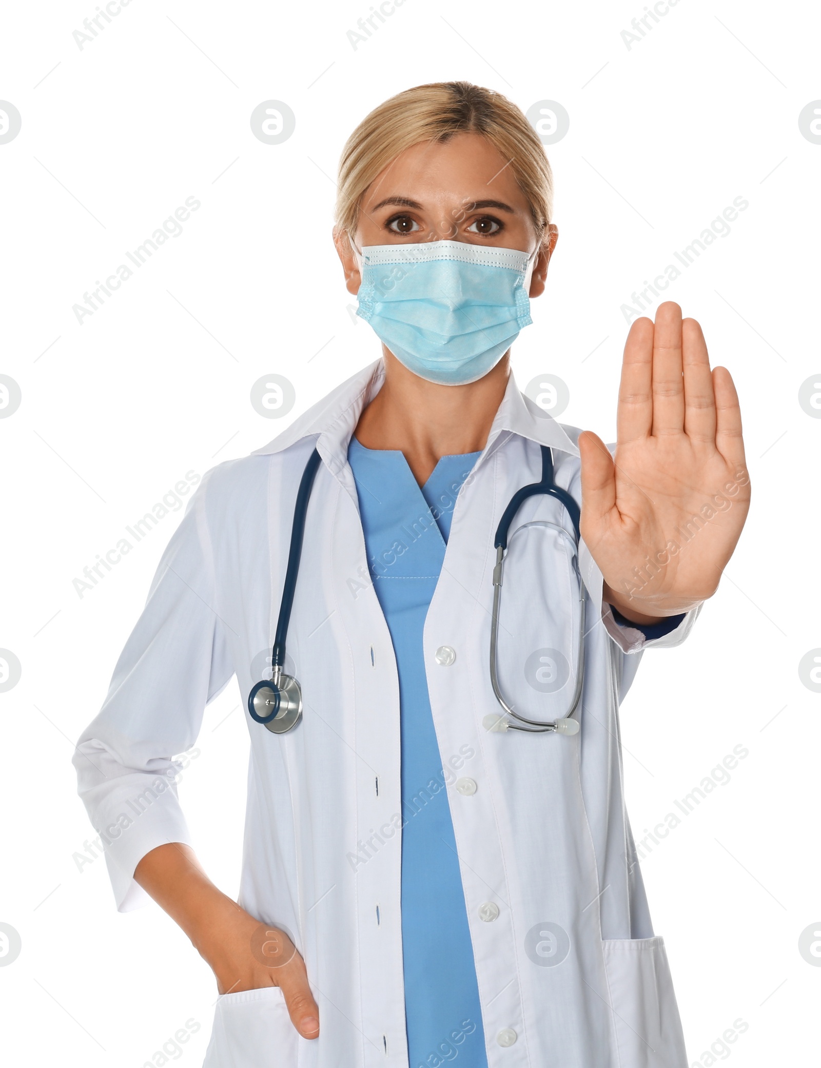 Photo of Doctor in protective mask showing stop gesture on white background. Prevent spreading of coronavirus