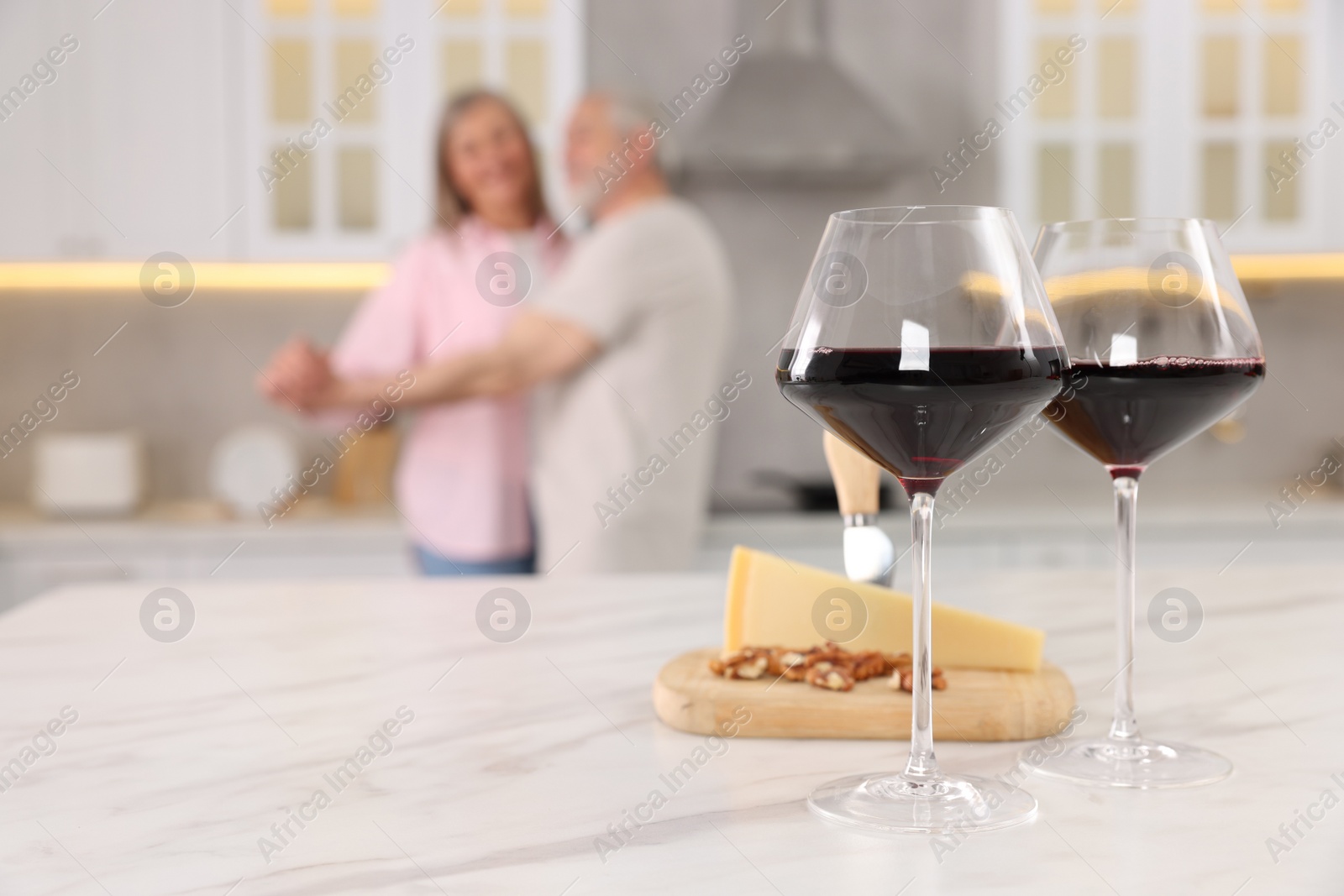 Photo of Senior couple dancing in kitchen, selective focus