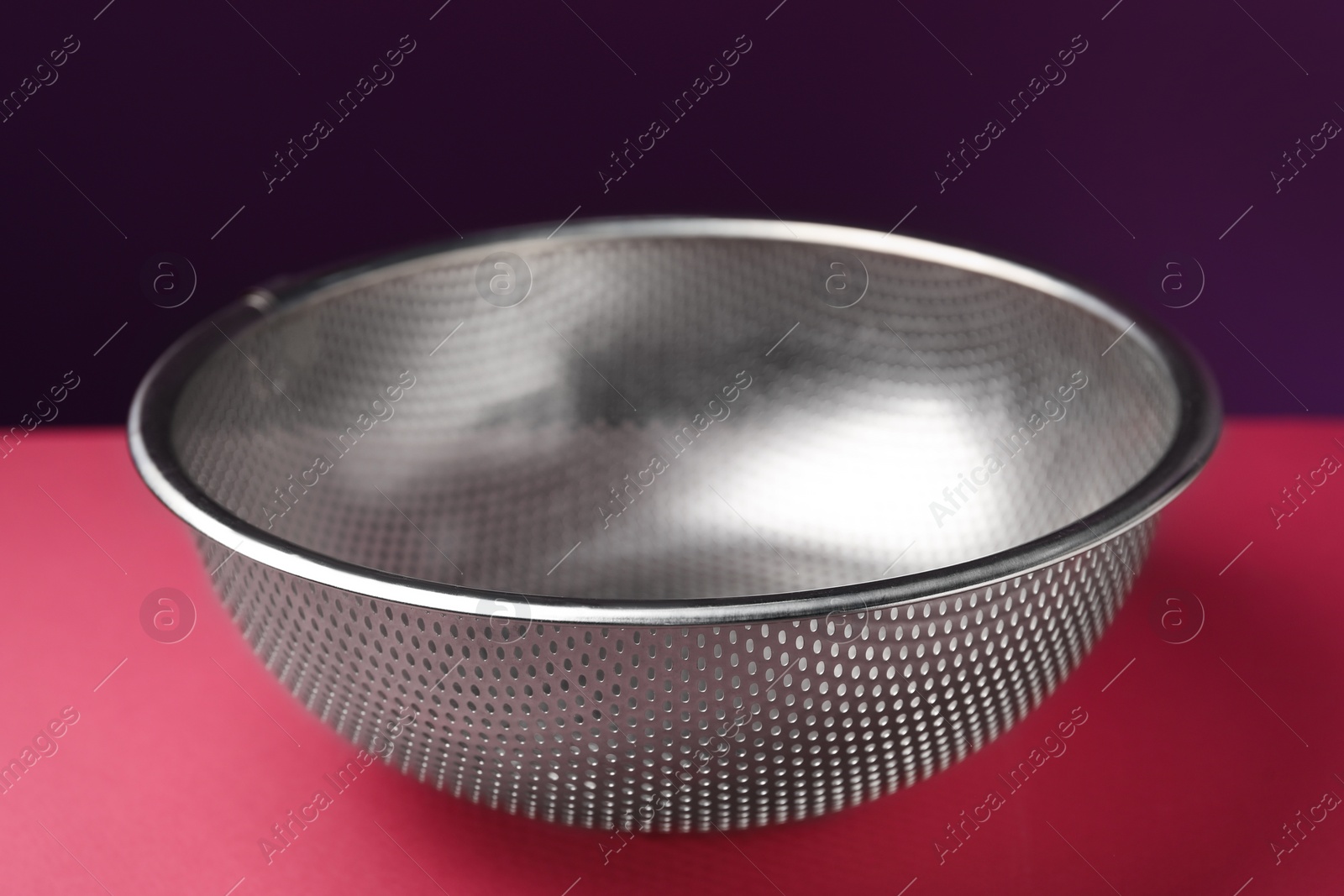 Photo of One clean empty colander on color background, closeup