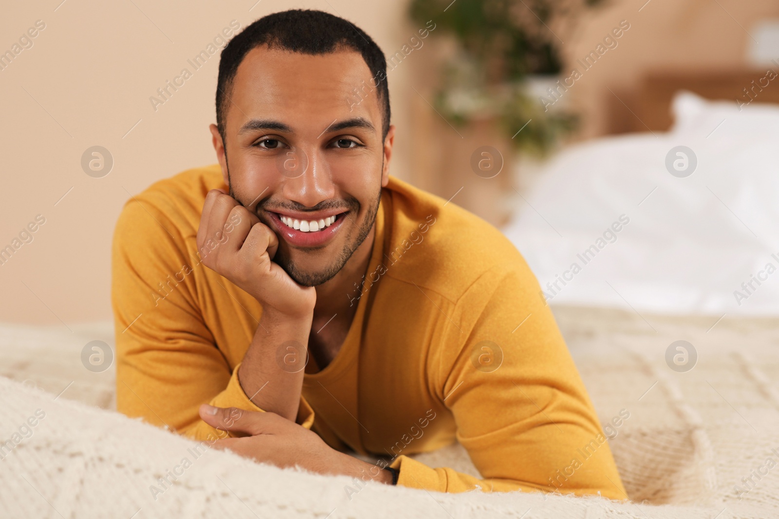 Photo of Portrait of smiling African American man on bed at home