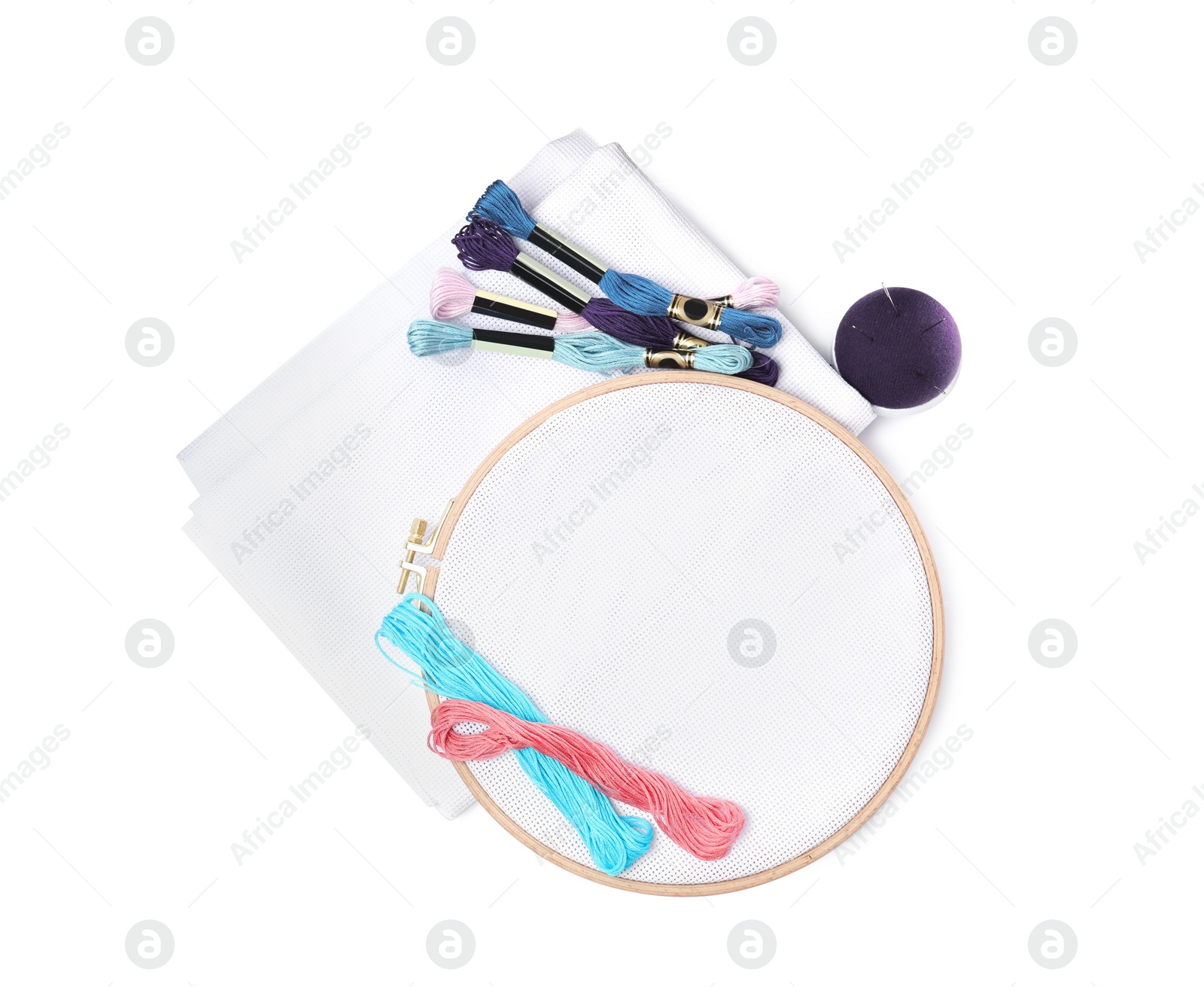 Photo of Colorful threads and different embroidery accessories on white background, top view