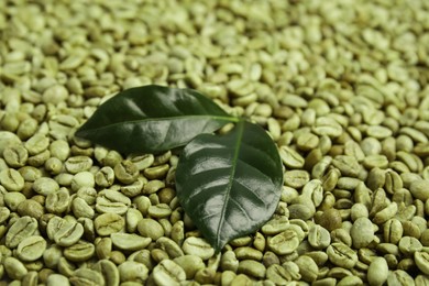 Lush leaves on pile of green coffee beans