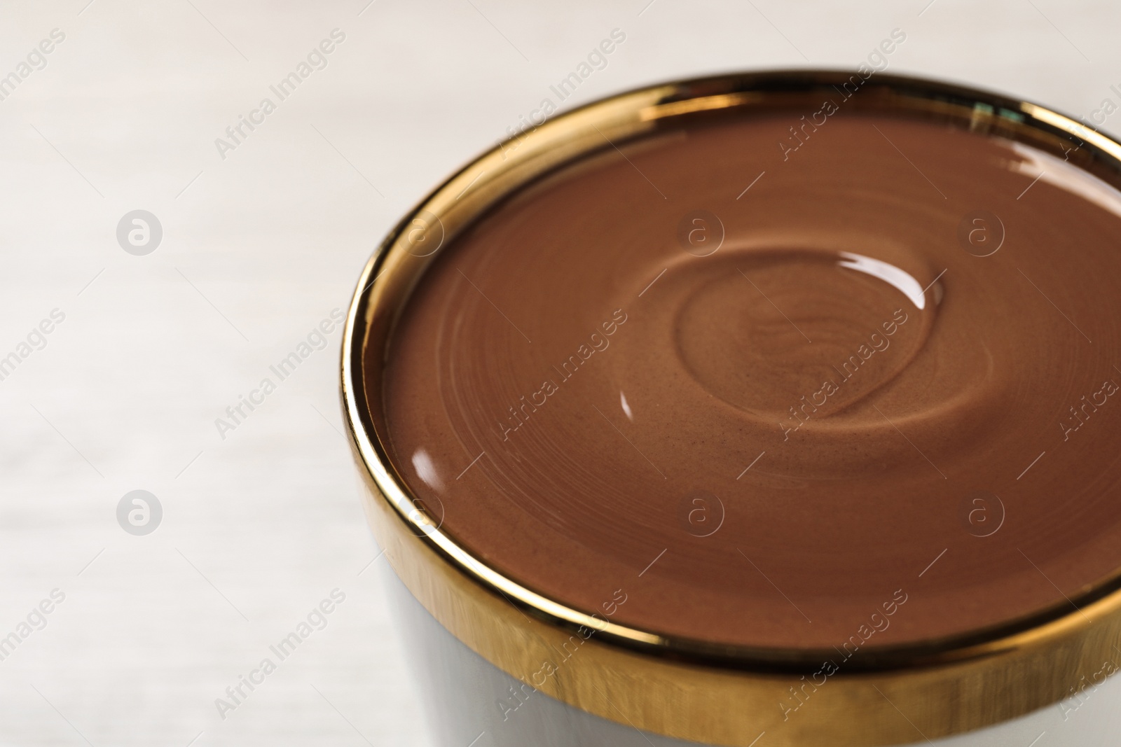 Photo of Yummy hot chocolate in cup on light background, closeup