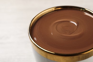 Photo of Yummy hot chocolate in cup on light background, closeup