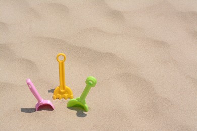Photo of Set of colorful beach toys on sand, space for text