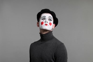 Portrait of mime artist in beret on grey background