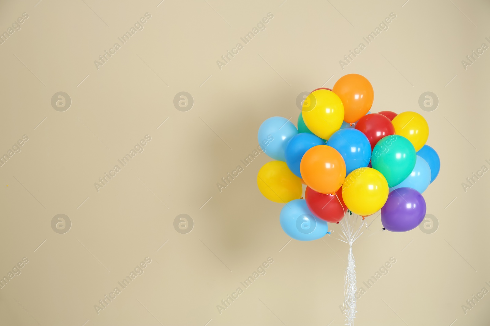 Photo of Bunch of bright balloons and space for text against color background